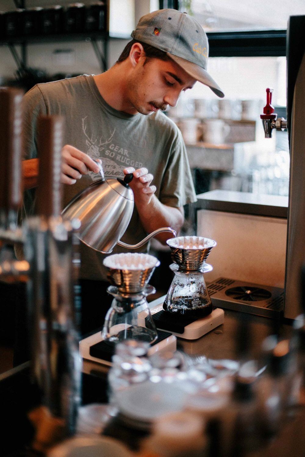 Dueño de un comercio preparando café detrás de la barra